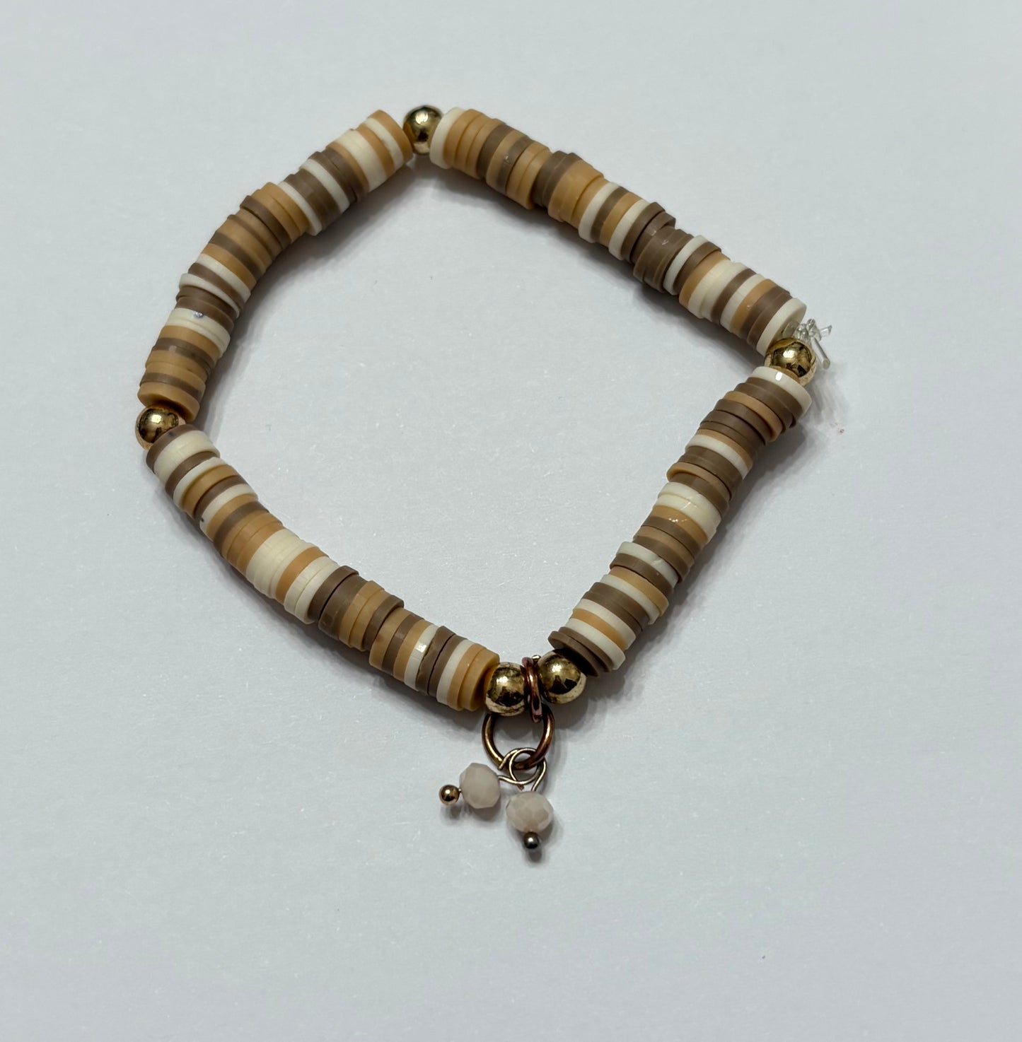Different shades of brown with a white charm in the middle and gold beads in between