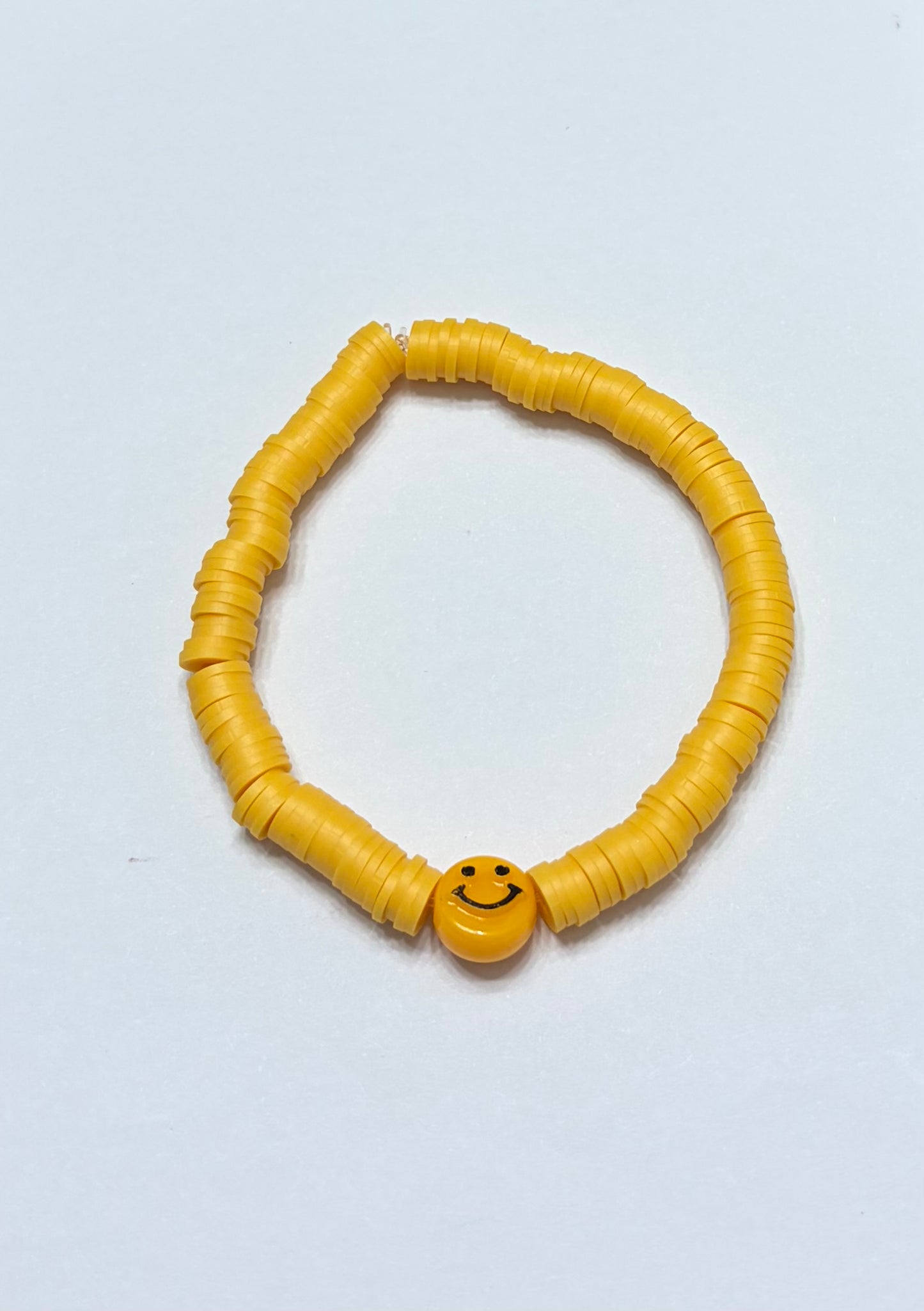 Yellow clay bead with yellow smiley face